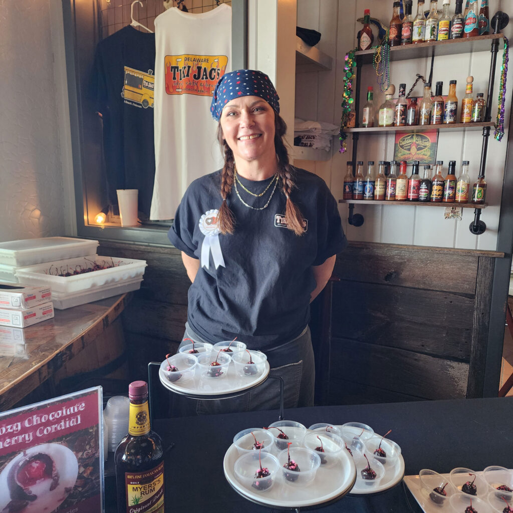 Jennifer Peterson displays Tiki Jac's Boozy Chocolate Cherry Cordial, which is a sumptuous dark rum infused maraschino cherry with a creamy center dipped in semi-sweet chocolate.