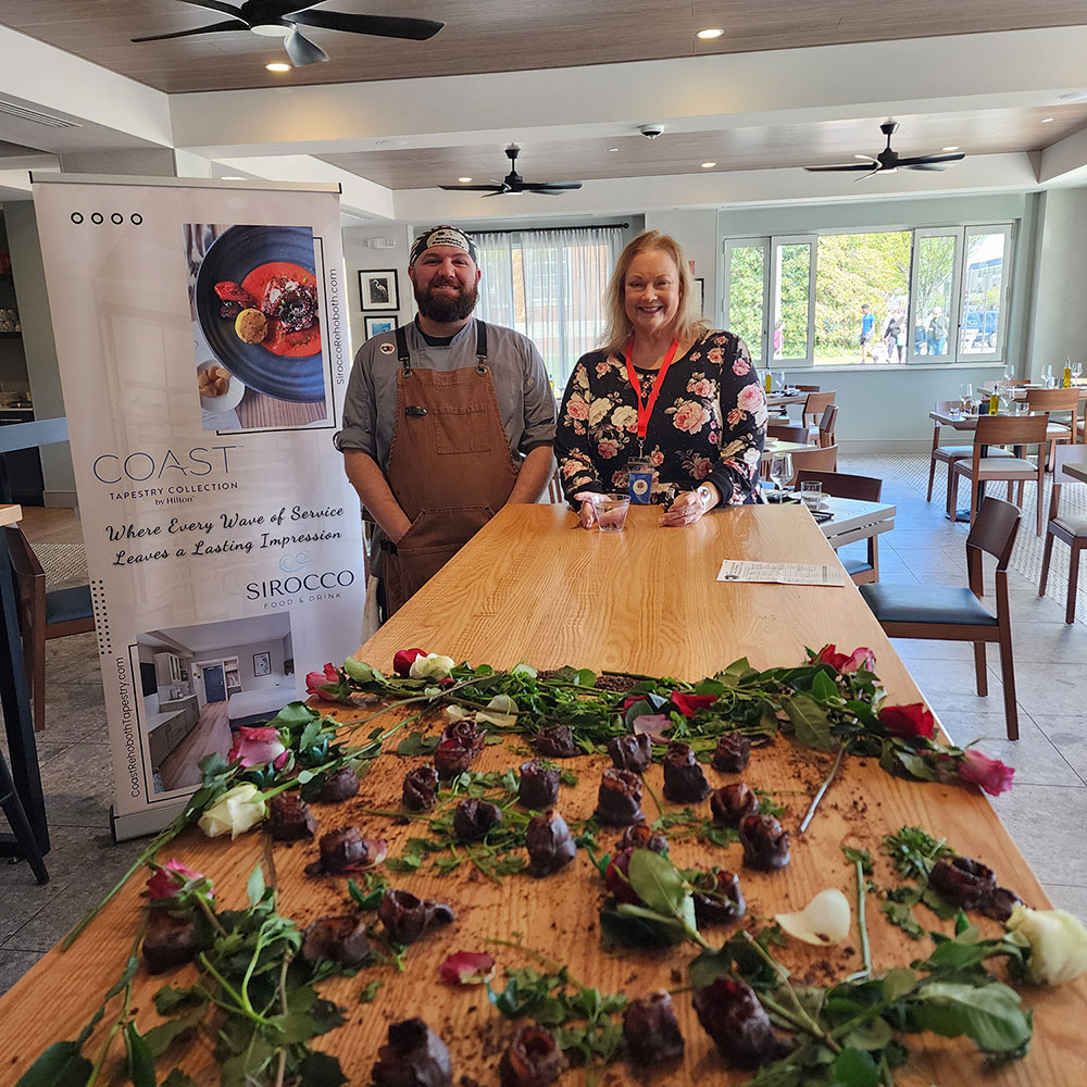 Sirocco’s Marcus, along with volunteer Gail, artistically exhibit real roses alongside the delectable thick-cut, pecan-smoked bacon roses candied in brown sugar espresso rub and dipped in semi-sweet chocolate.